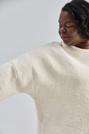 woman wearing a size small handwoven cream sweater with black pants