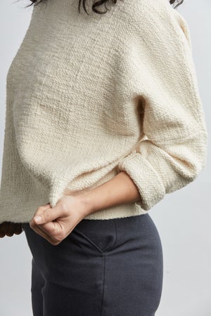 woman wearing a size small handwoven cream sweater with black pants