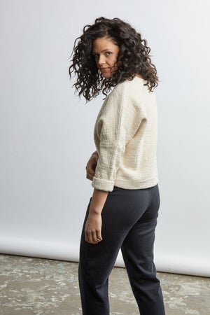 woman wearing a size small handwoven cream sweater with black pants
