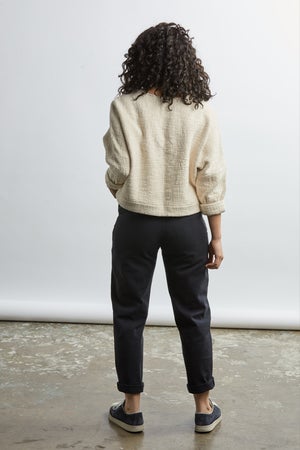 woman wearing a size small handwoven cream sweater with black pants